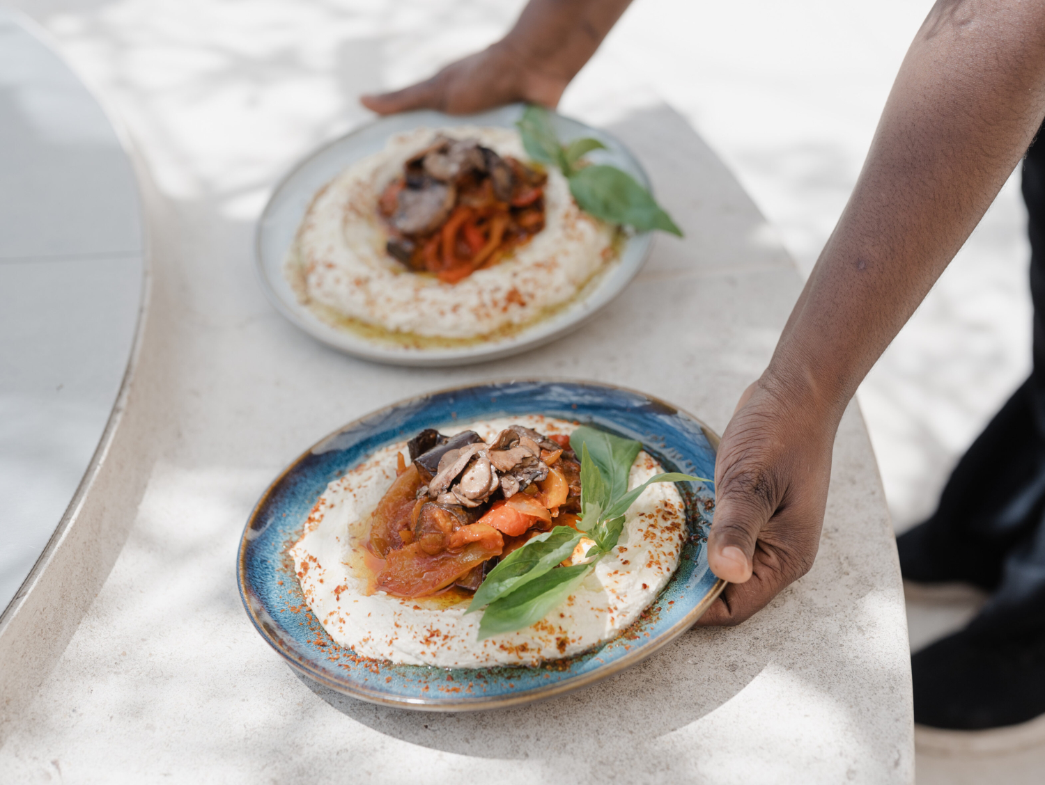 Presetnation of two plates of food served at Chiche! at Mudam Café. Photo: Marion Dessard © Mudam Luxembourg