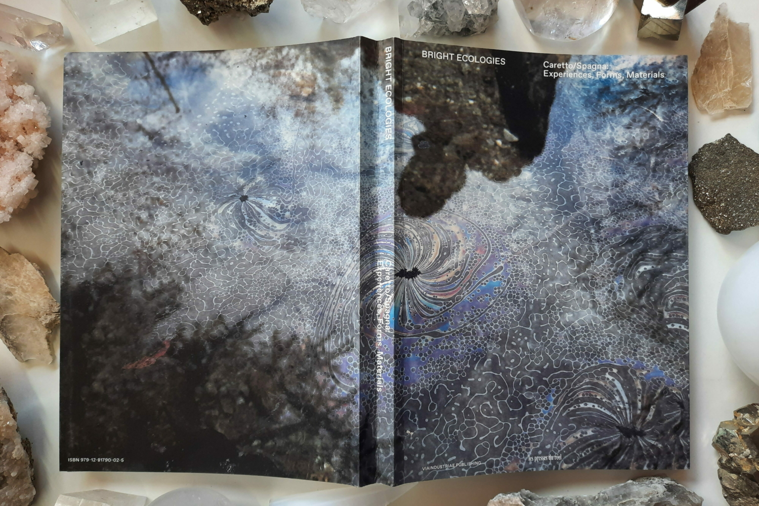 A beautifully decorated book cover with diverse stones laid on its sides.